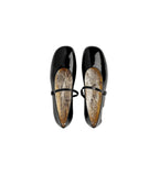 Pair of black patent leather shoes with a white background