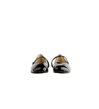 Pair of black patent leather shoes on a white background