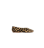 A single flat shoe in tan suede with a black leopard print pattern, shown in a side profile against a light gray background.