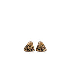 A pair of slip-on loafers with a tan and black leopard print pattern, shown from the front on a light gray background.