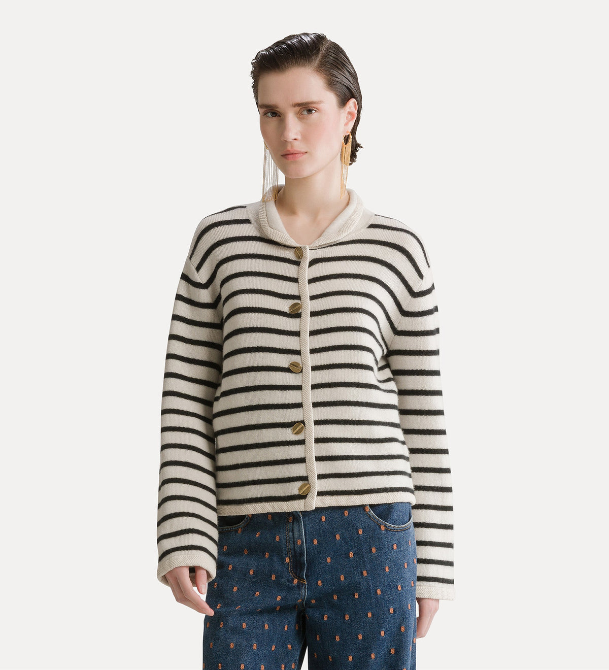 Woman wearing a striped cardigan and jeans on a white background