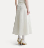 An off-white A-line midi skirt with a tie waist, shown on a model from the back wearing white tights and gold high heels against a light gray background.