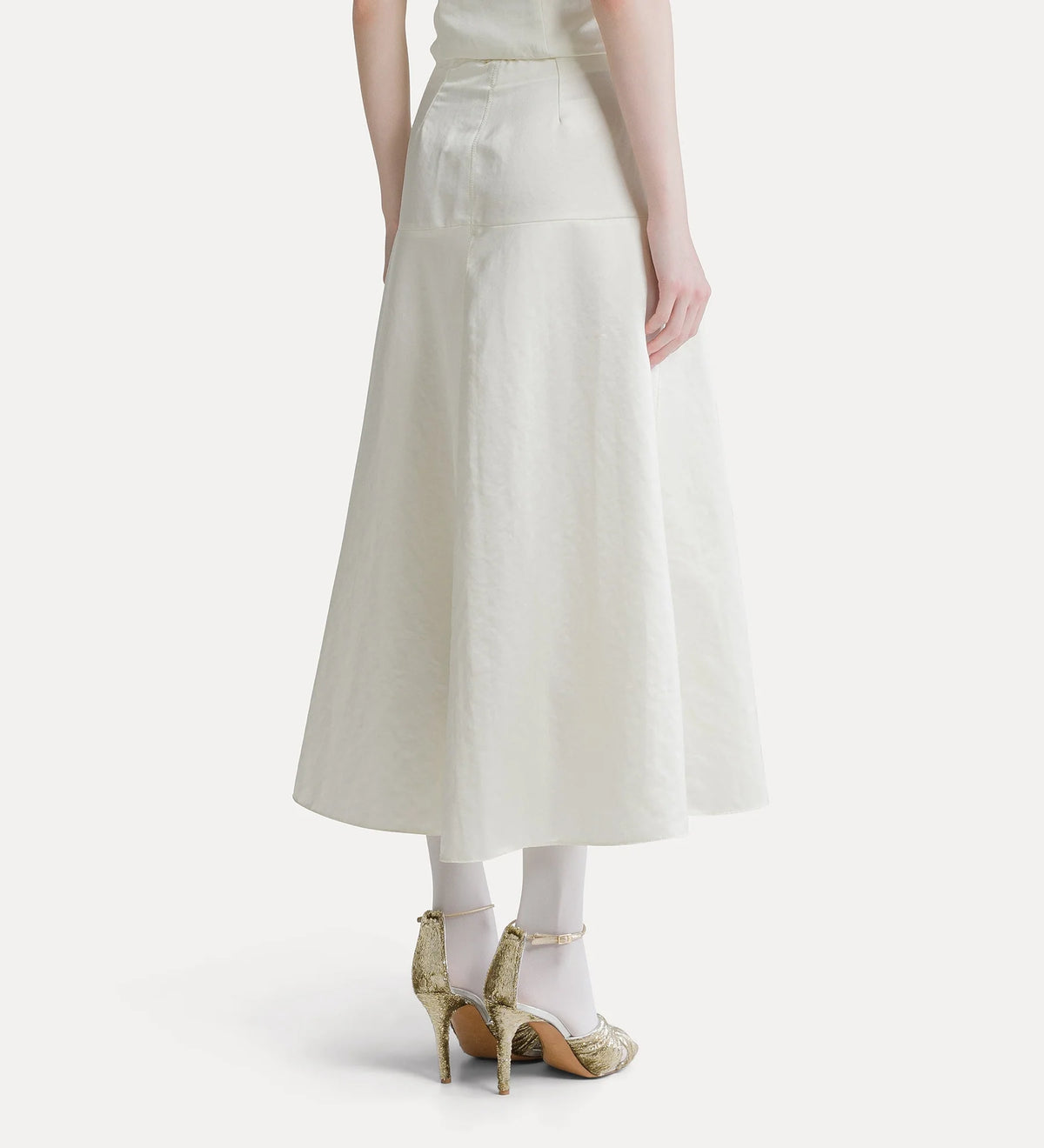 An off-white A-line midi skirt with a tie waist, shown on a model from the back wearing white tights and gold high heels against a light gray background.