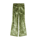 Green velvet wide-leg pants with an all-over snakeskin pattern, shown flat against a light gray background.