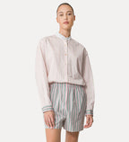 A model wearing a striped grandad shirt with a collar and contrasting fabric on the cuffs, paired with matching striped shorts.