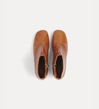 Pair of brown leather ankle boots on a white background