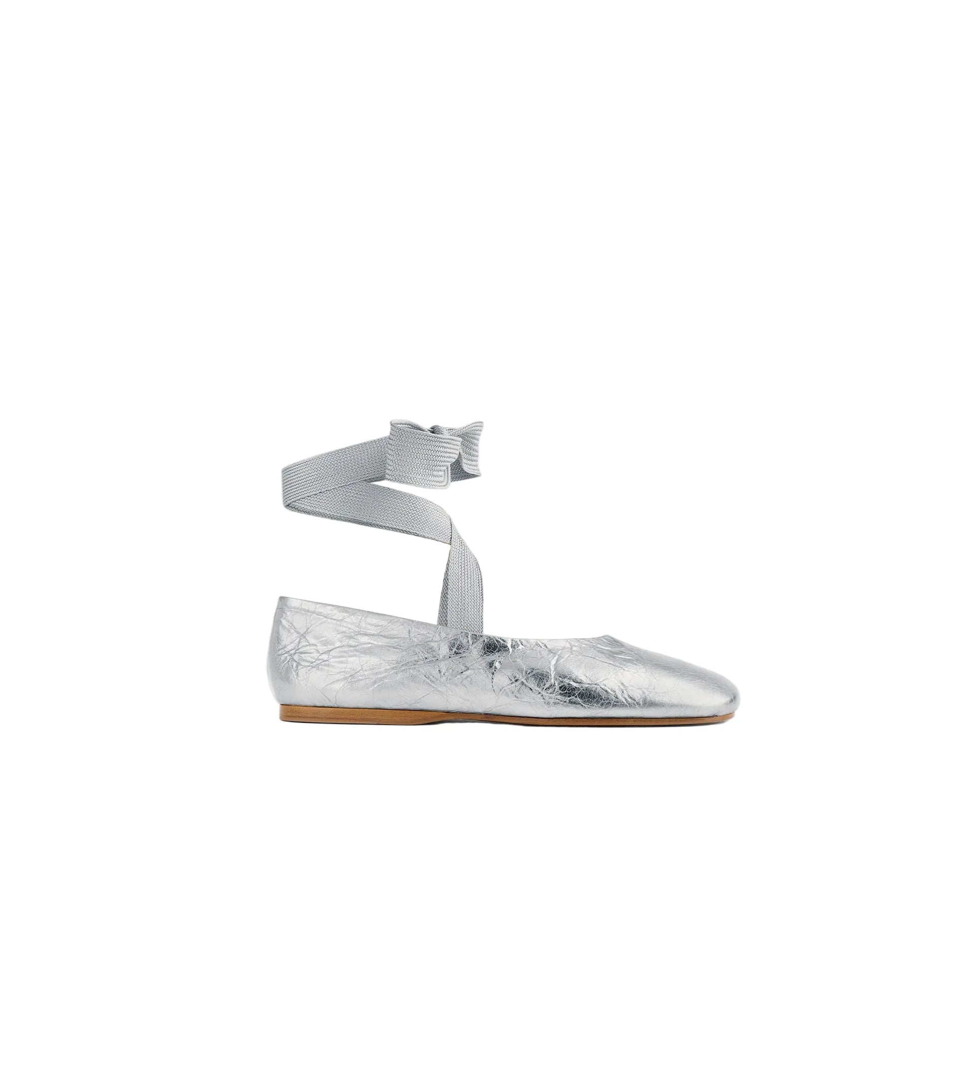 Silver flat shoe with ankle strap on a white background