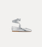 Silver flat shoe with ankle strap on a white background