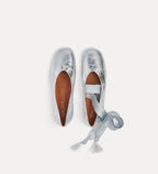 Silver ballet flats with a strap on a white background