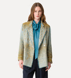 Woman wearing a patterned blazer over a blue shirt on a white background