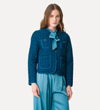 Woman wearing a blue quilted jacket and pants on a white background