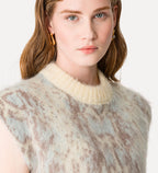 Woman wearing a patterned sleeveless top with a neutral background