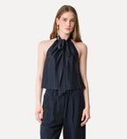 Woman wearing a black halter top and pants on a white background