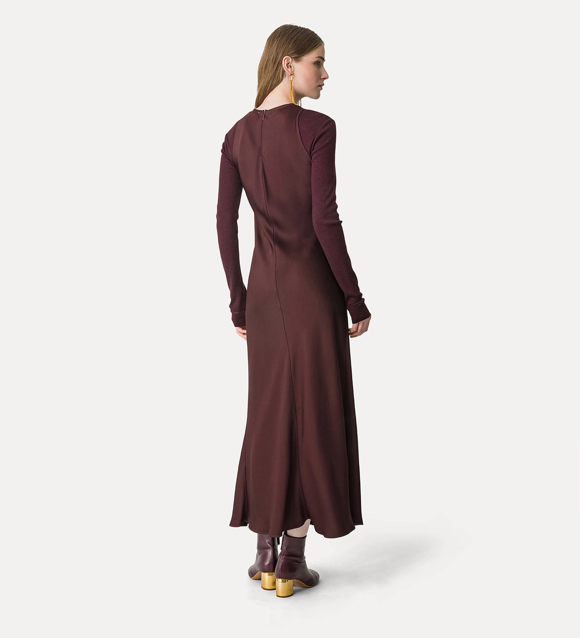 Woman wearing a long burgundy dress on a white background