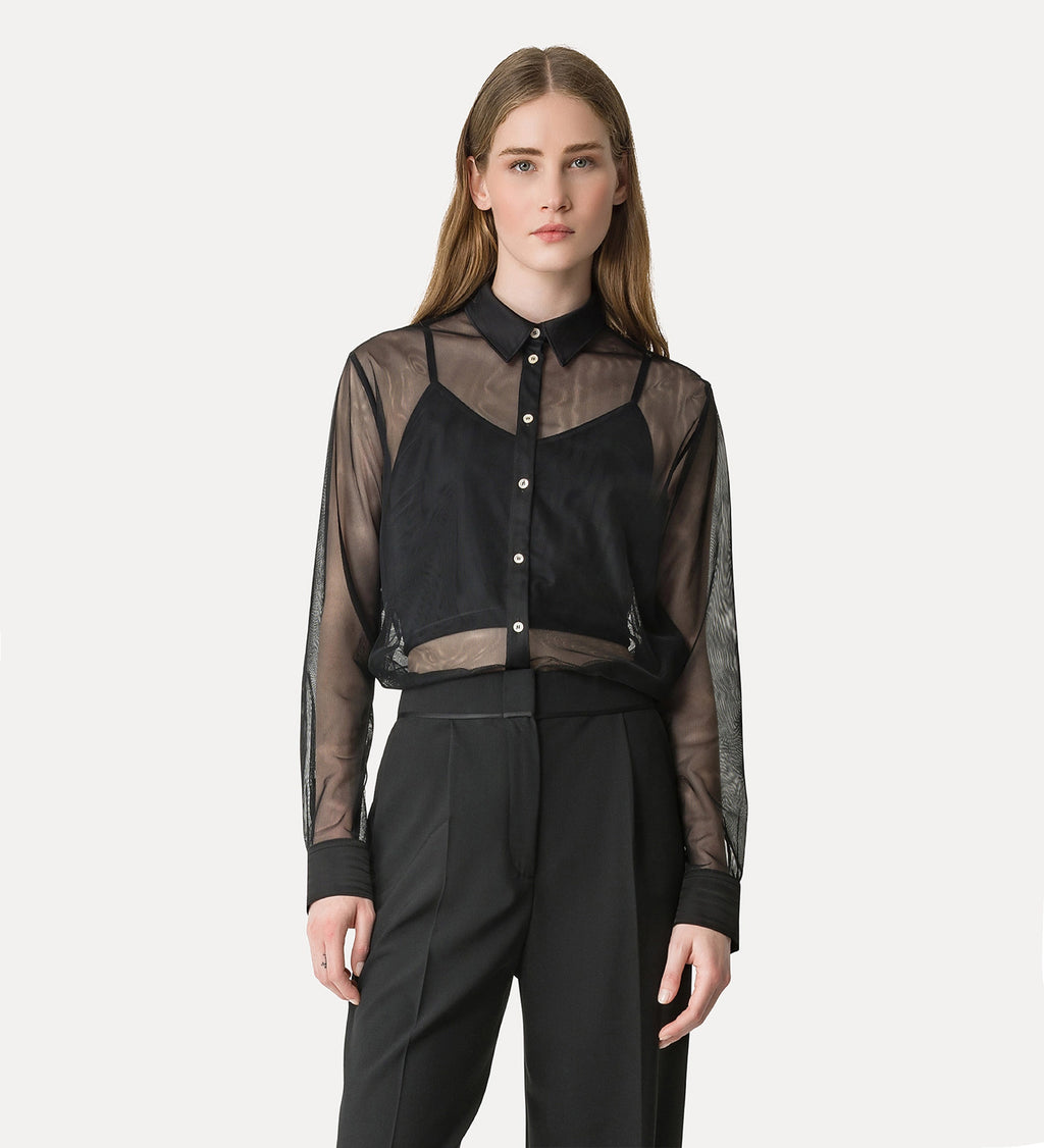 Woman wearing a black and sheer blouse with a white background