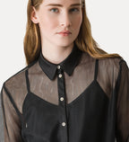 Woman wearing a black and sheer blouse with a plain background