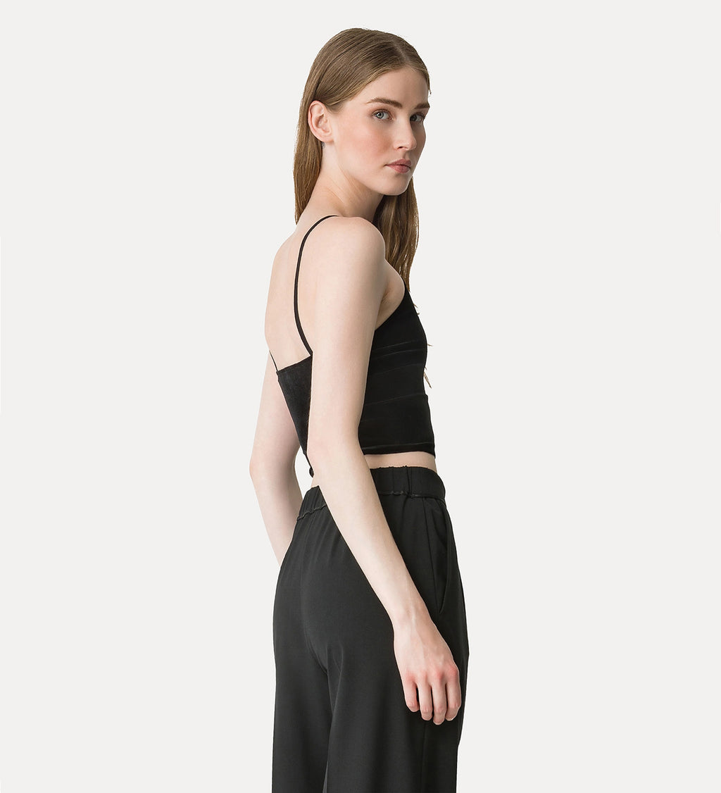 Woman wearing a black sleeveless top and black pants on a white background