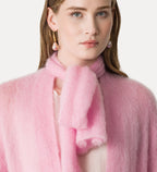 Woman wearing a pink scarf with a plain background