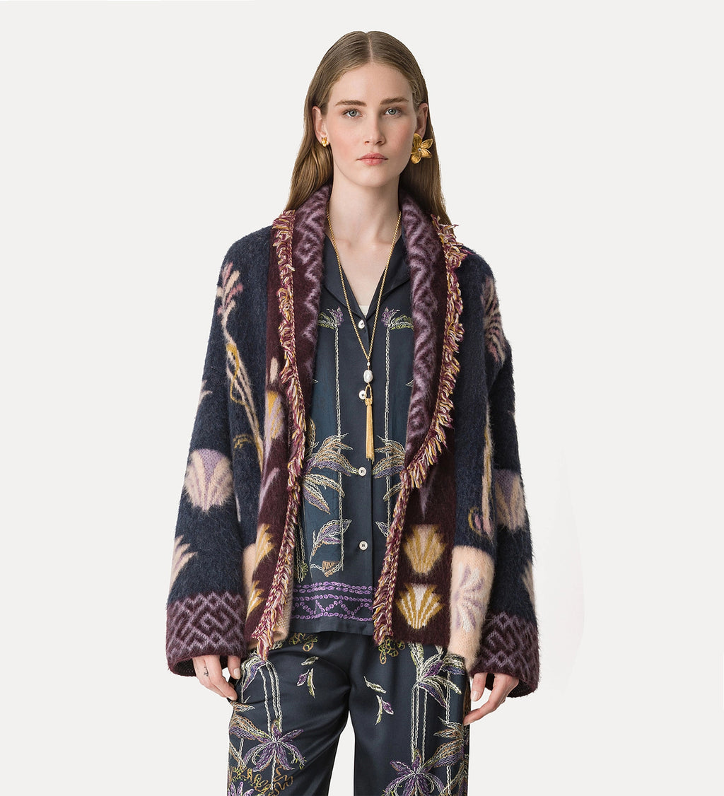 Woman wearing a patterned cardigan with a white background