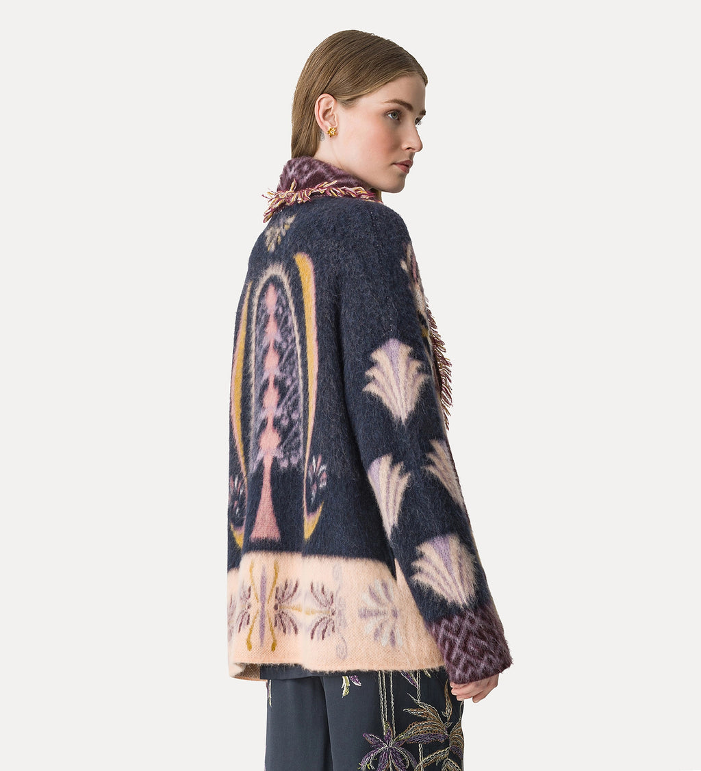 Woman wearing a patterned cardigan with a white background