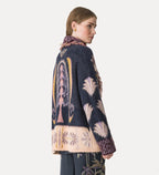 Woman wearing a patterned cardigan with a white background