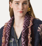 Close-up of a person wearing a dark blue embroidered shirt with a purple fur collar against a white background