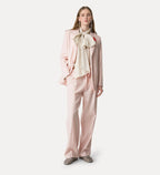 Woman wearing a light pink outfit with a bow tie on a white background