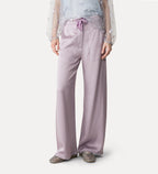 Person wearing light purple satin pants on a white background