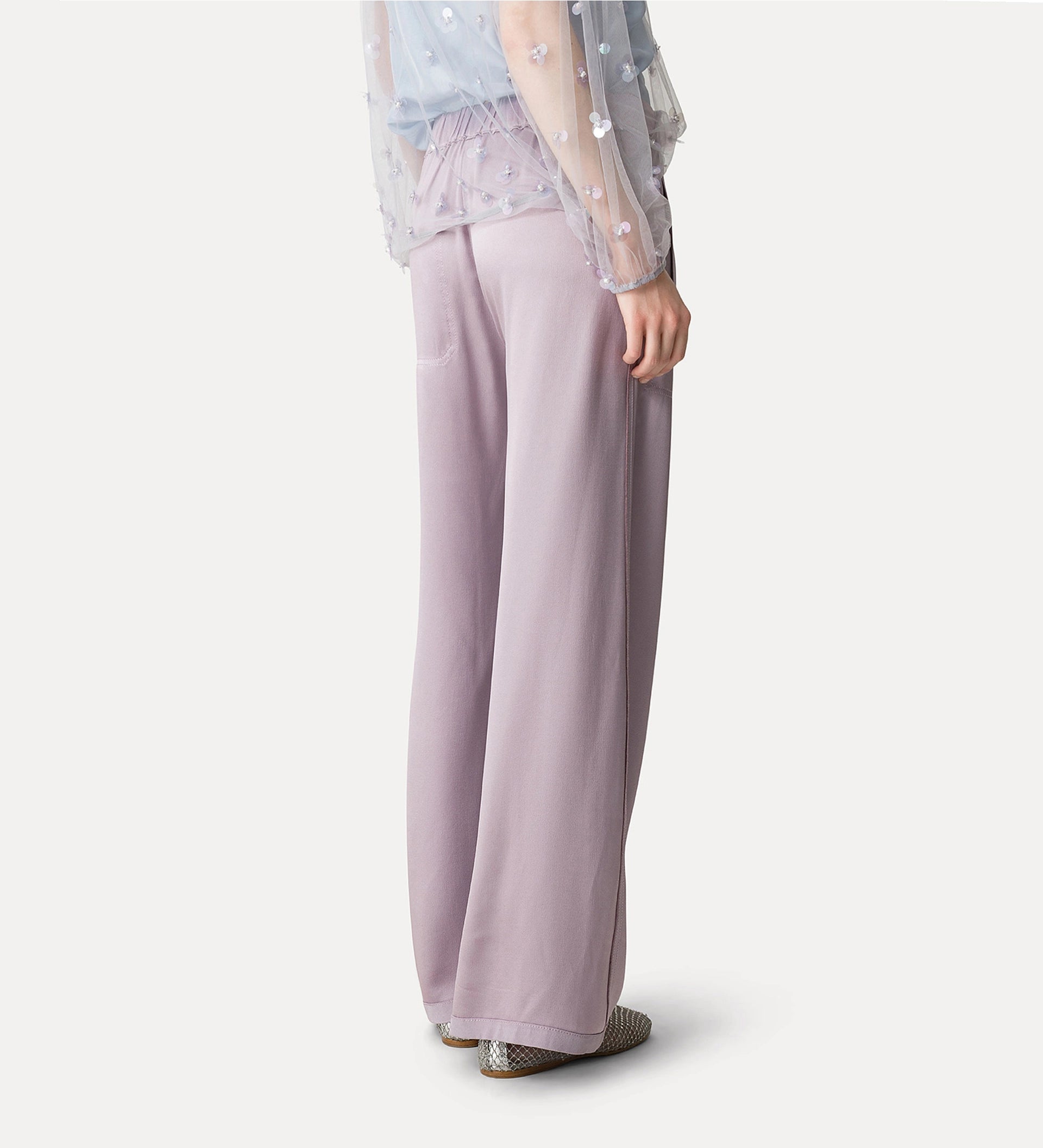 Person wearing light purple wide-leg pants on a white background