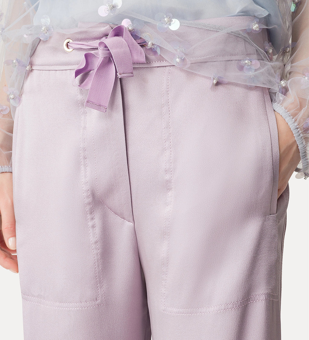 Light purple pants with a decorative bow and sheer overlay