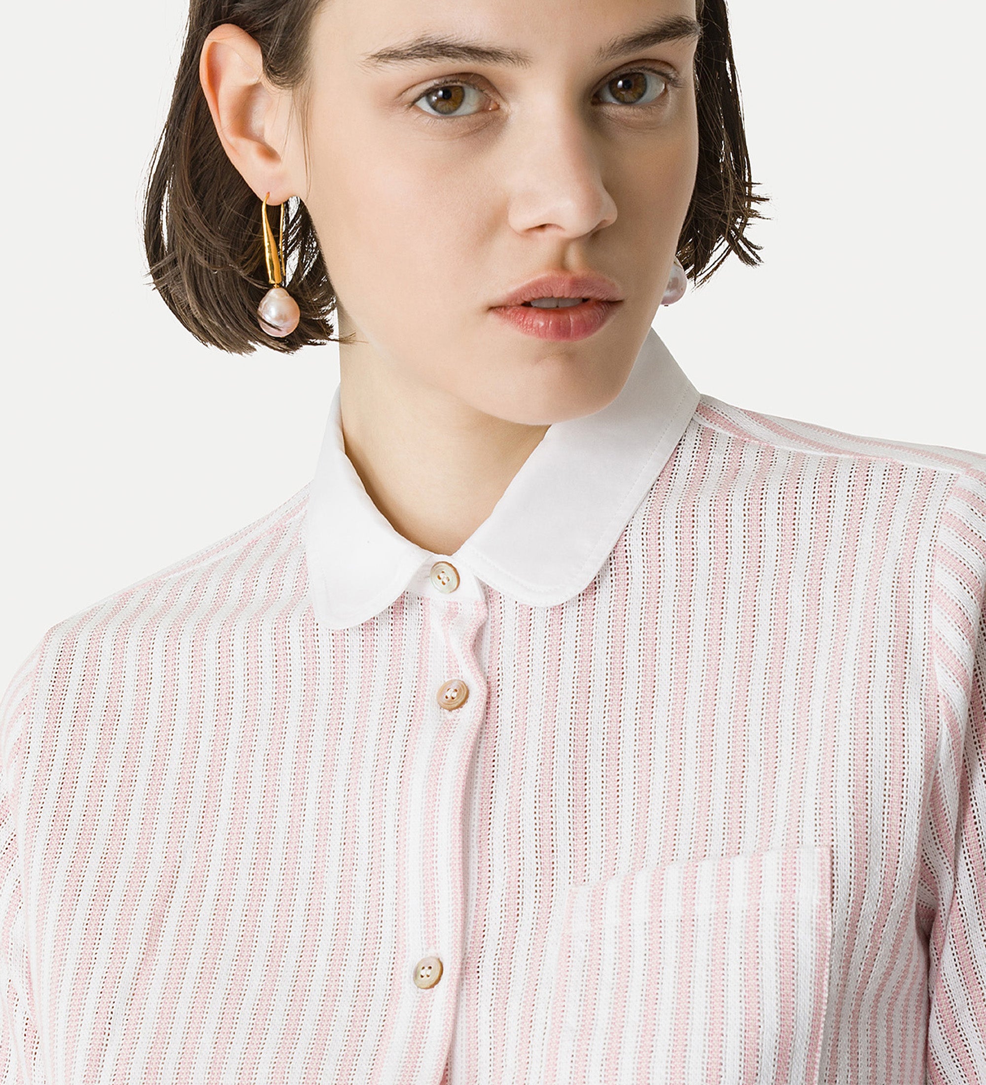 Person wearing a pink and white striped shirt with a white collar.