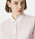 Person wearing a pink and white striped shirt with a white collar.