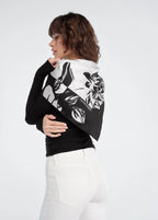Woman wearing a black and white patterned scarf on a plain background