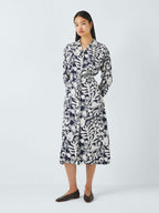Woman wearing a black and white patterned dress on a white background