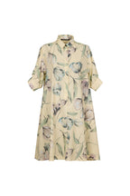 A short-sleeve button-up shirt dress in a light beige or cream color, featuring a watercolor-style floral print with muted green leaves and lavender-purple flowers, shown against a solid light blue-gray background.
be28st-k.4057
Hannes Roether