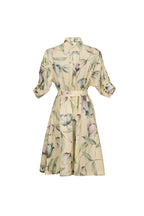 A cream-colored shirt dress with a green and gray floral print, featuring three-quarter sleeves and a matching waist tie, shown against a light blue-gray background.
be28st-k.4057
Hannes Roether