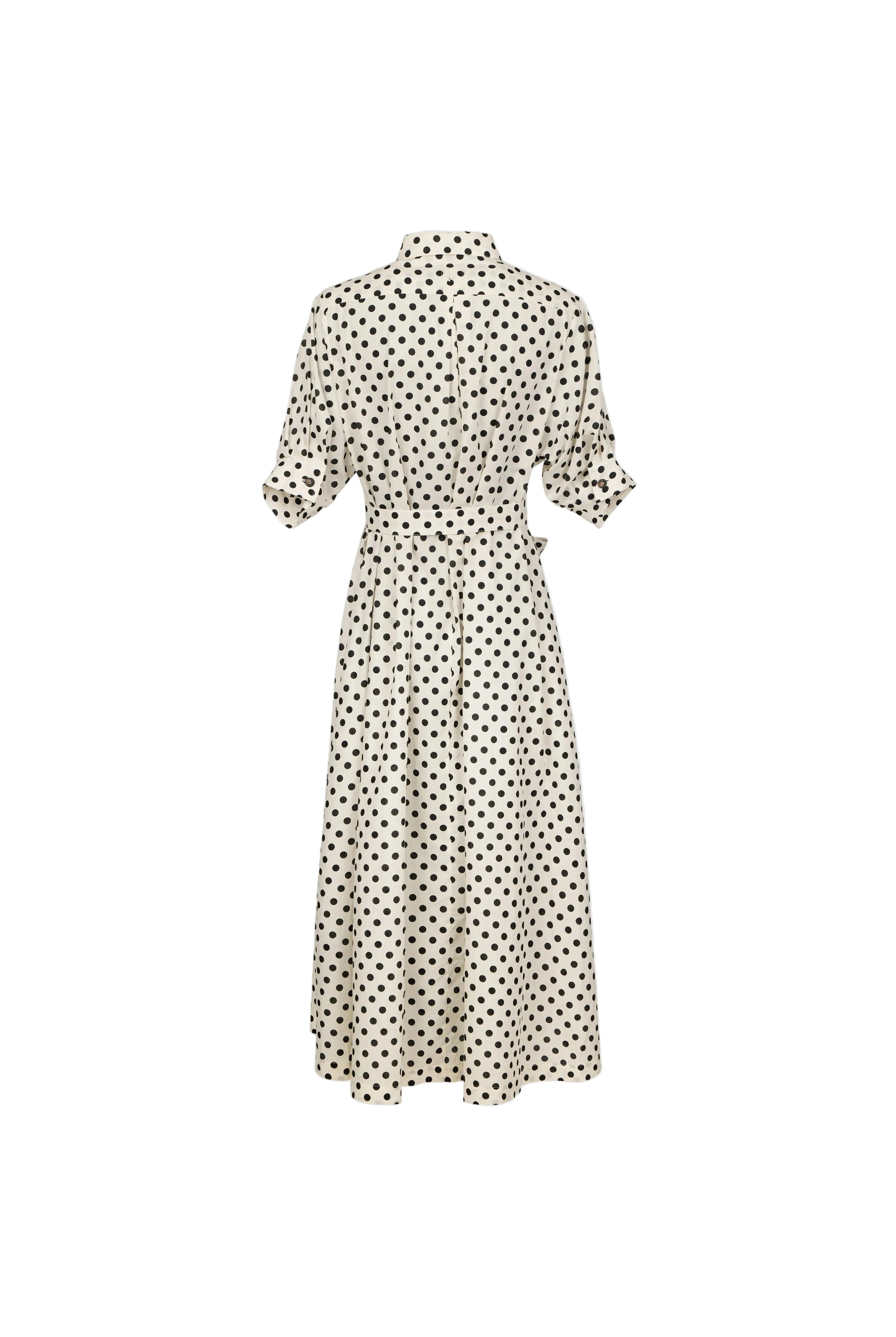 A cream-colored midi dress with a black polka dot pattern, featuring short puff sleeves and a button-up collar, shown from the back against a light blue-gray background.
bet28ter-k.4061
Hannes Roether