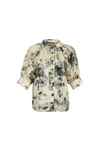 A women's short-sleeve blouse with a gathered, ruffled neckline and a watercolor-style floral print in muted gray, black, and soft pink on a cream background, shown against a light blue-gray studio background.

do29di.4059
hannes roether