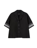 Black shirt with striped sleeves on a light gray background