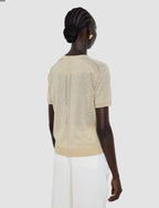 Woman wearing a beige knit top with a subtle pattern on a white background