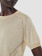 Beige knit top with intricate detailing on a neutral background