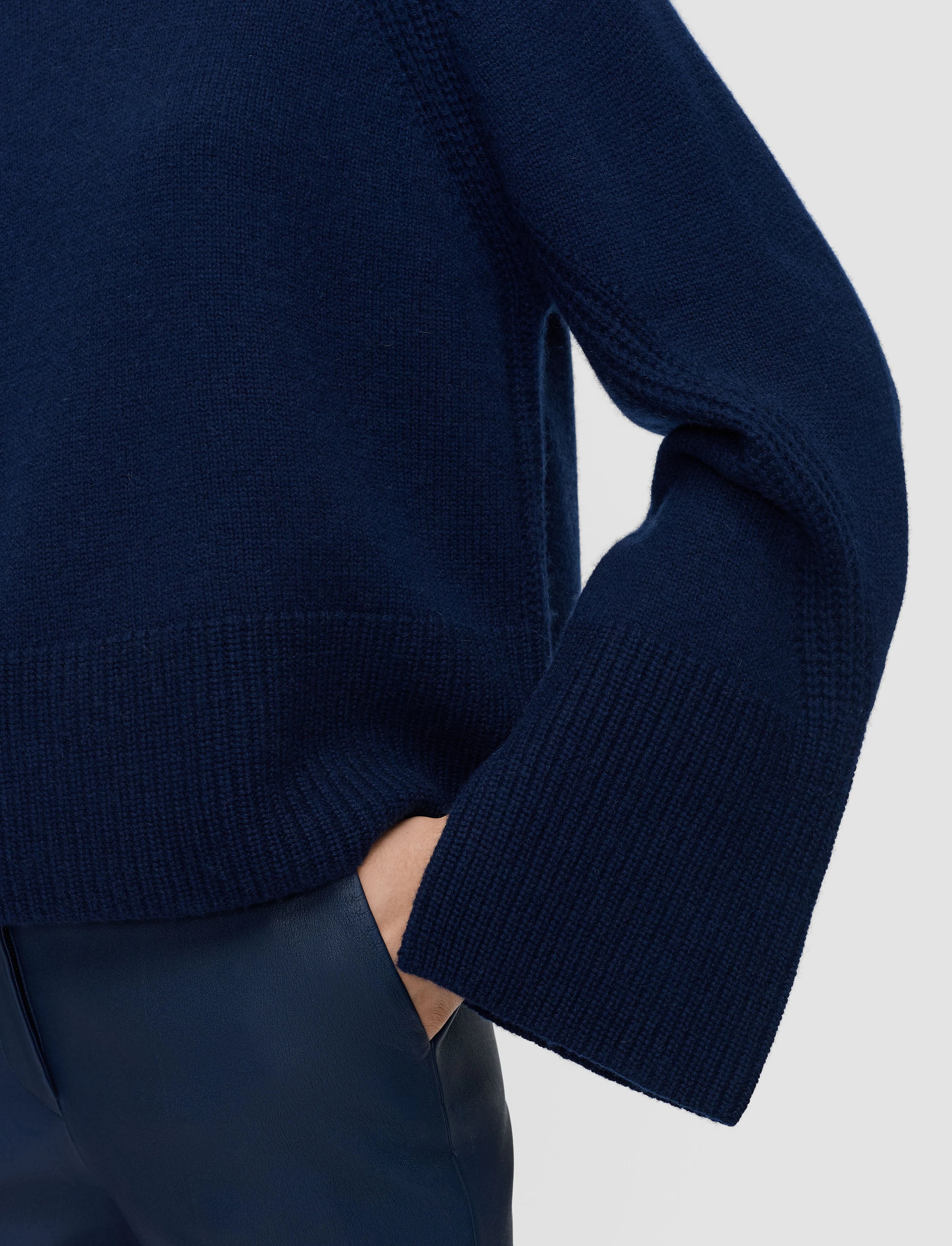 Navy blue sweater worn by a person on a light gray background