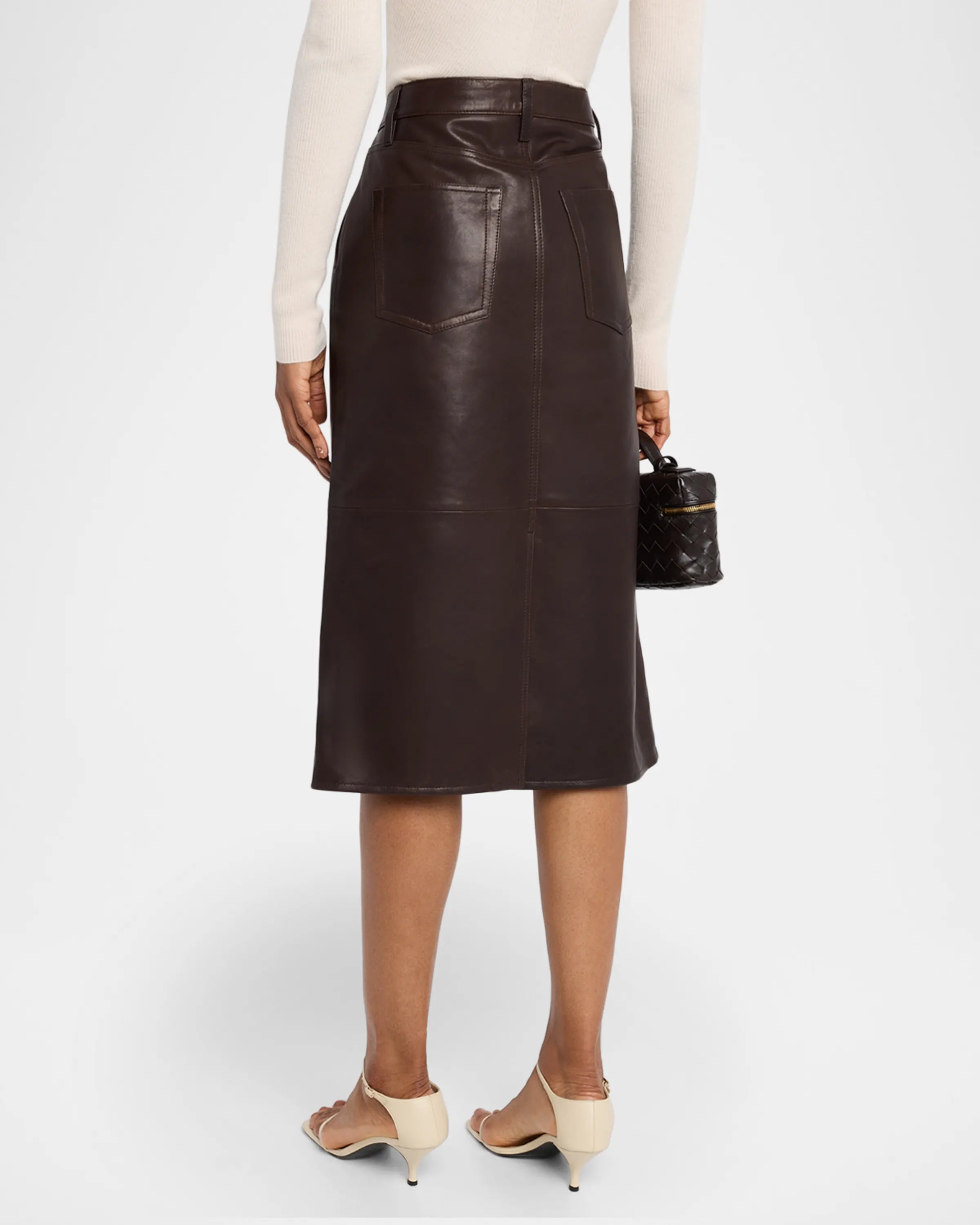 Person wearing a brown leather skirt on a white background