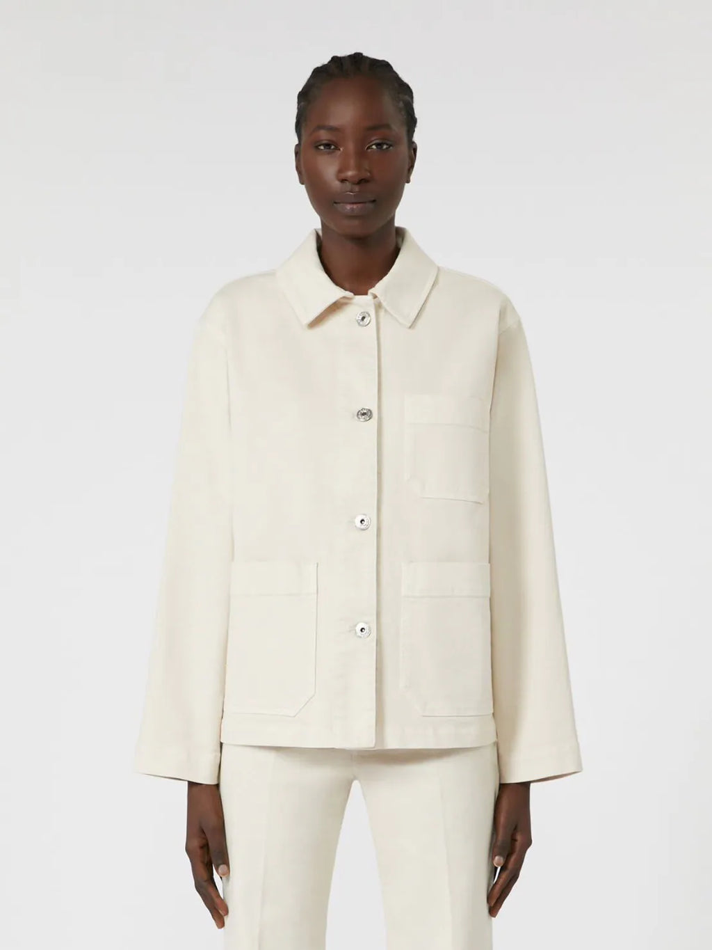 Person wearing a cream-colored jacket and pants on a white background