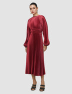Woman wearing a red pleated dress on a white background
