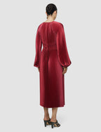 Red pleated dress worn by a person on a white background
