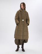 Person wearing a long olive green coat on a white background