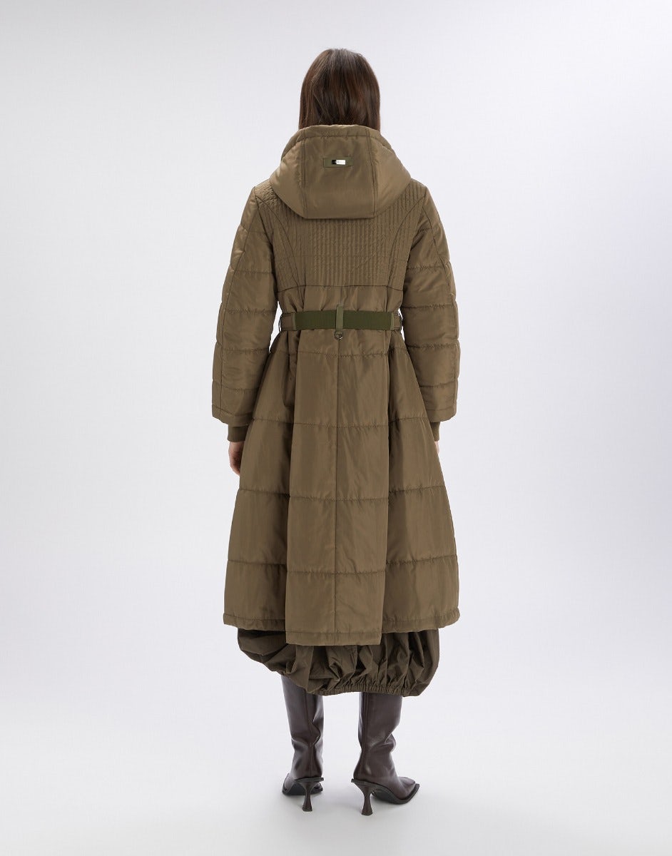 Person wearing a long olive green coat on a white background