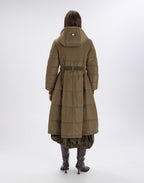 Person wearing a long olive green coat on a white background