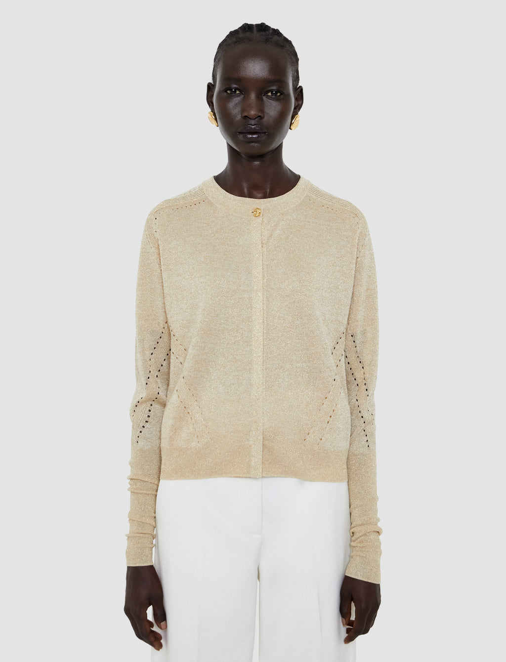 Woman wearing a beige knit cardigan on a white background